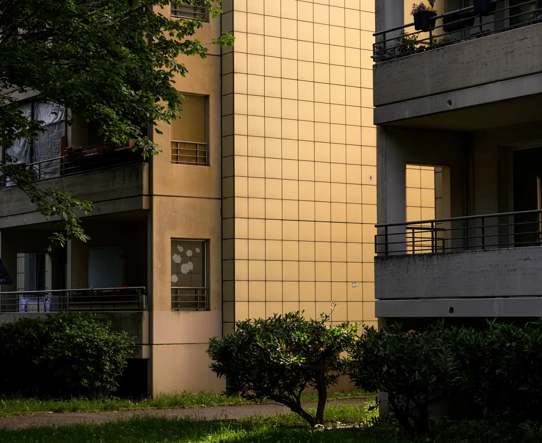 Mehrgeschossige Berliner Wohnanlage mit Balkonen, Bäumen und gepflegten Grünflächen